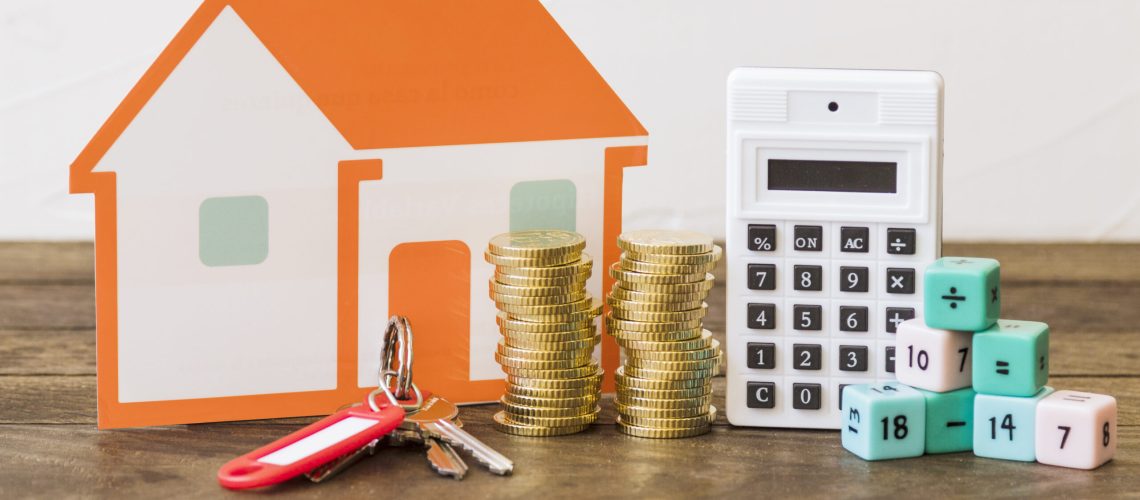 house-key-stacked-coins-calculator-math-blocks-wooden-table